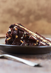 Piece of Chocolate Cake on a Plate. Rustic stone background. Copy space.	