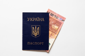 Ukrainian passport and 10 euro banknote on white background, financial aid, payments