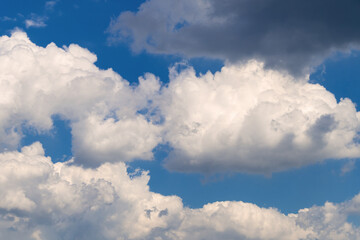 Naklejka premium Fluffy white clouds against a vibrant blue sky on a sunny day