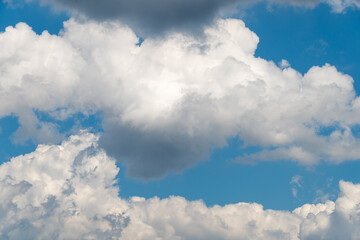 Fluffy white clouds against a bright blue sky on a sunny day