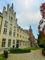 Obraz premium Linear facade of modern buildings in Leuven with tower and green surroundings