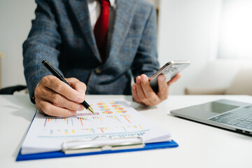 Businessman hand using smart phone laptop and tablet with social network diagram on desk as concep