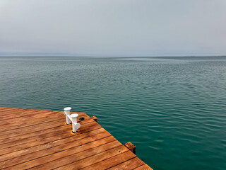Corner of wooden pier above calm lake surface