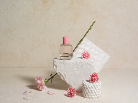 Elegant arrangement with a glass cosmetics bottle and pink flowers