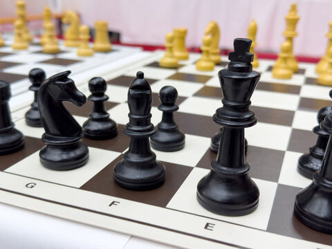 Intense close-up of chess game with black and white pieces on board - Powered by Adobe