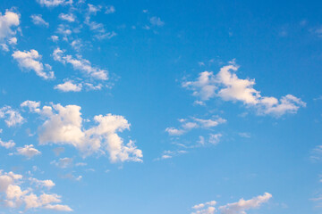 blue sky with clouds on a sunny august morning. climate change. fluffy formations in bright weather. blue nature backdrop in morning light. warm forecast background
