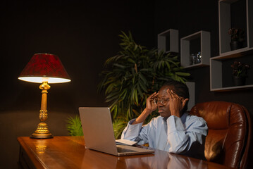 Young african american businesswoman massaging her temples, feeling exhausted and suffering from a...