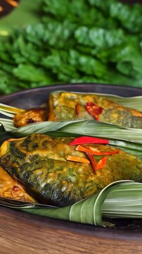 Cambodian amok, a traditional steamed fish dish wrapped in banana leaves and cooked in a fragrant curry paste and coconut milk. This ethnic specialty showcases the unique flavors