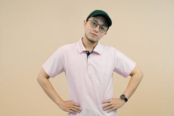 casual young man in pink polo shirt and cap posing confidently