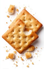 Two crispy crackers, one broken apart, scattered crumbs