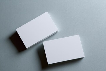 Two blank business cards on a light gray surface