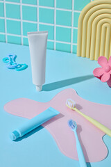 A clean bathroom counter with personal care tools and toothpaste in front of a teal mosaic tile wall. Light-filled and minimal for modern ads.