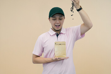 enthusiastic man pouring coffee beans into bag against neutral background