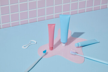 An organized pink-themed setup with toothpaste tube, mirror, floss pick, and water glass over pastel tile wall. Soft and feminine branding tone.