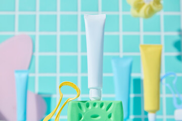 A colorful layout of pastel toothpaste tubes and floss picks placed neatly in front of a green...