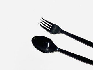 black plastic cutlery spoon and fork on white background 