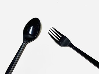 black plastic cutlery spoon and fork on white background 