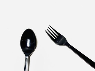 black plastic cutlery spoon and fork on white background 