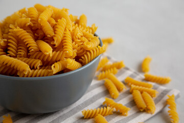 Dry Fusilli Pasta in a Bowl, low angle view. Copy space.