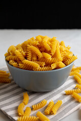 Dry Fusilli Pasta in a Bowl, low angle view. Close-up.