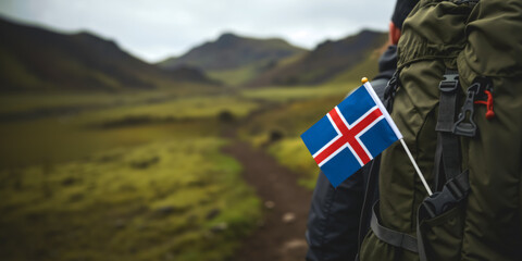 Back view of Icelandic flag on hiker backpack trekking through misty highlands. Close up of travel adventure and patriotism in Iceland wilderness. Exploring nature. Copy space for text.