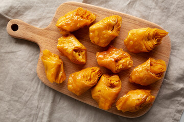 Sweet Homemade Turkish Baklava with Honey on a Wooden Board, top view.