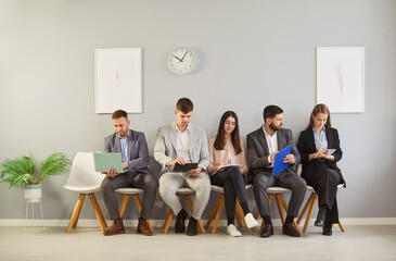 Young hr applicants sitting in queue preparing for important interview in office, vacancy candidates waiting on chairs holding resume, human resources, people hiring and job search, worried before