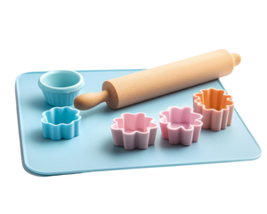 Colorful baking tools ready for cookie-making, featuring rolling pin and flower-shaped cutters on a blue mat.