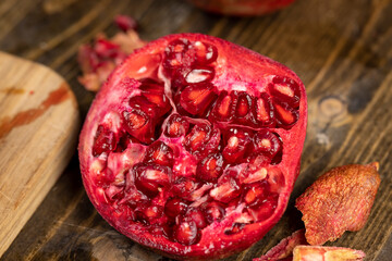 sliced red pomegranate on a table, sweet red pomegranate cut into pieces during cooking