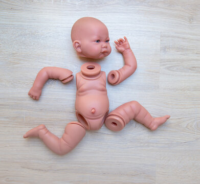 baby doll disassembled into parts lies on a shelf in the form of a runner