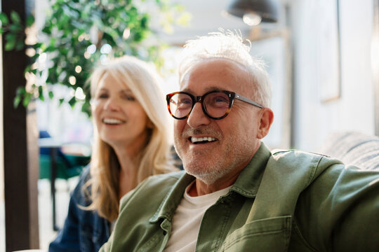 Senior couple relaxing on a sofa at home, laughing and enjoying their time together