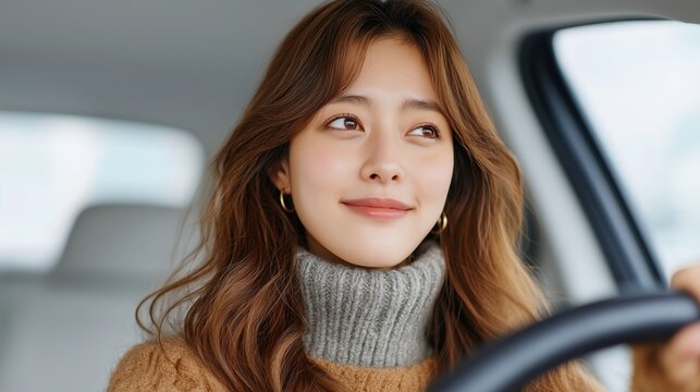 Asian young woman smiling confidently while driving a car. Conveys freedom, confidence, driver school and automotive safety, insurance or transportation