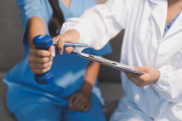 Unrecognizable uses blue hand weight during physical therapy session