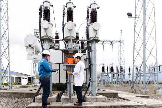 Engineers conducting a transformer voltage check at a wind farm