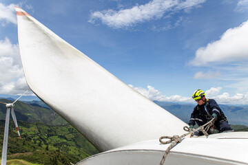Engineer performing maintenance on a wind turbine nacelle outdoors