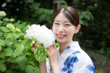 紫陽花と浴衣のかわいい女性のクローズアップ　カメラ目線