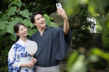 浴衣でスマホを持つ自撮りするカップル　観光や旅行などのイメージ