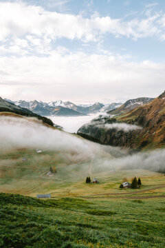 Sonnenaufgang in den Alpen mit Nebel im Tal und Schnee auf den Bergen