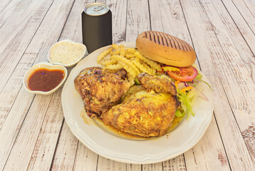 A plate of roasted chicken at a kebab restaurant with pita bread and sauces