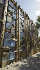 Obraz premium unique architectural structure features vertical arrangement of wooden beams and glass boxes, creating innovative and artistic facade. design integrates natural elements and modern aesthetics