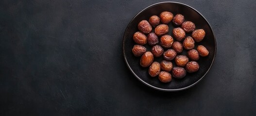 Dark bowl of dried dates on dark background