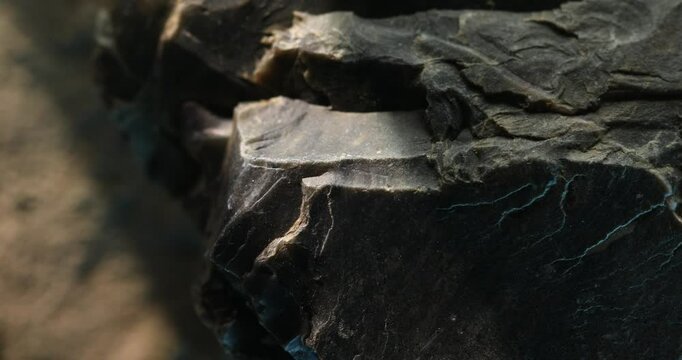 Close-up of jagged slate edge with layered structure and dramatic shadows