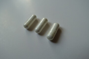 Oblong white capsules of acetyl cysteine dietary supplement (three items)