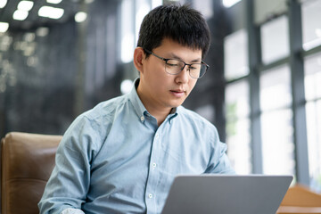 asian businessman working on laptop in office