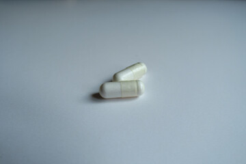 Oblong white capsules of acetyl cysteine dietary supplement (two items)