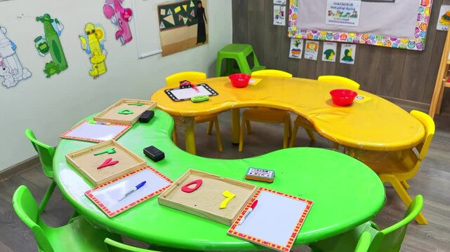 4K footage of vibrant preschool tables with sand trays, whiteboards, and educational toys. Ideal for school promos, learning content, or classroom visuals. Category: Education &ndash; Preschool Setup.