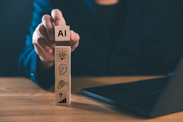 A businessman stacking wooden blocks with AI and technology icons, representing artificial...
