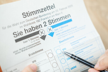 Empowered female voter voting in democratic election, ballot paper German federal elections, electoral integrity, citizens voting rights, political choices in Germany, Frankfurt - February 9, 2025