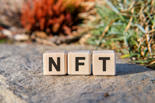 NFT - text on cubes standing on a stone on a natural background