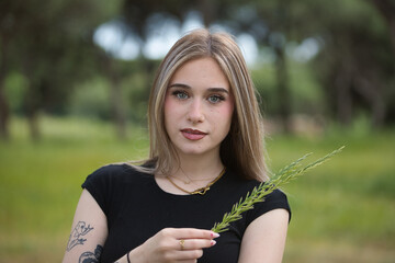 Portrait of a young woman, beautiful, blonde, green eyes, wearing a black t-shirt, sweet and...